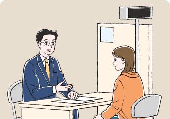 役所で医療費助成について話を聞いている女性と説明しているスーツ姿の職員