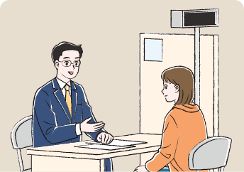 役所で医療費助成について話を聞いている女性と説明しているスーツ姿の職員